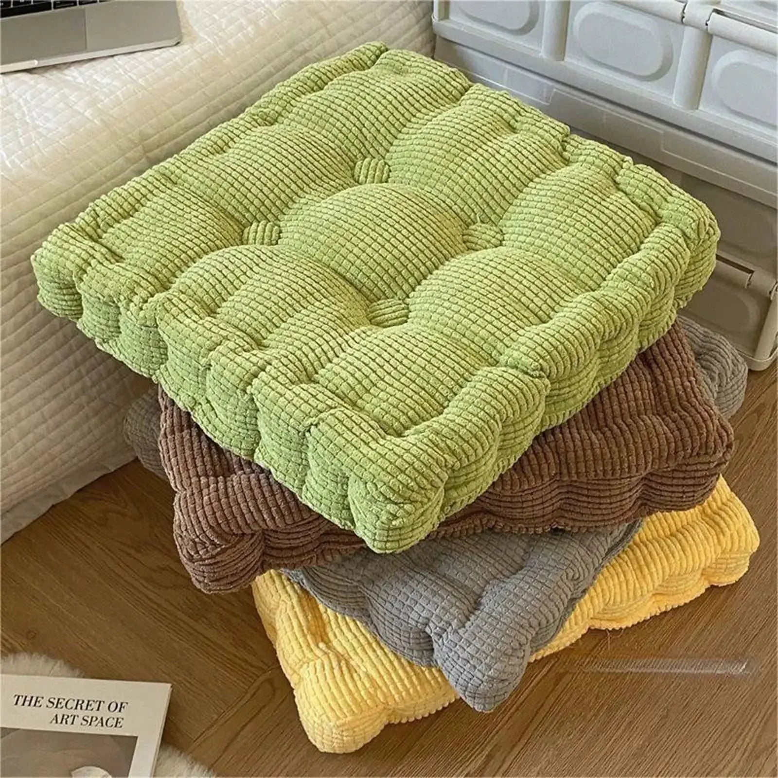 Thick square knee pillow in lime green with ribbed textile texture; four cushions stacked in brown, gray and yellow