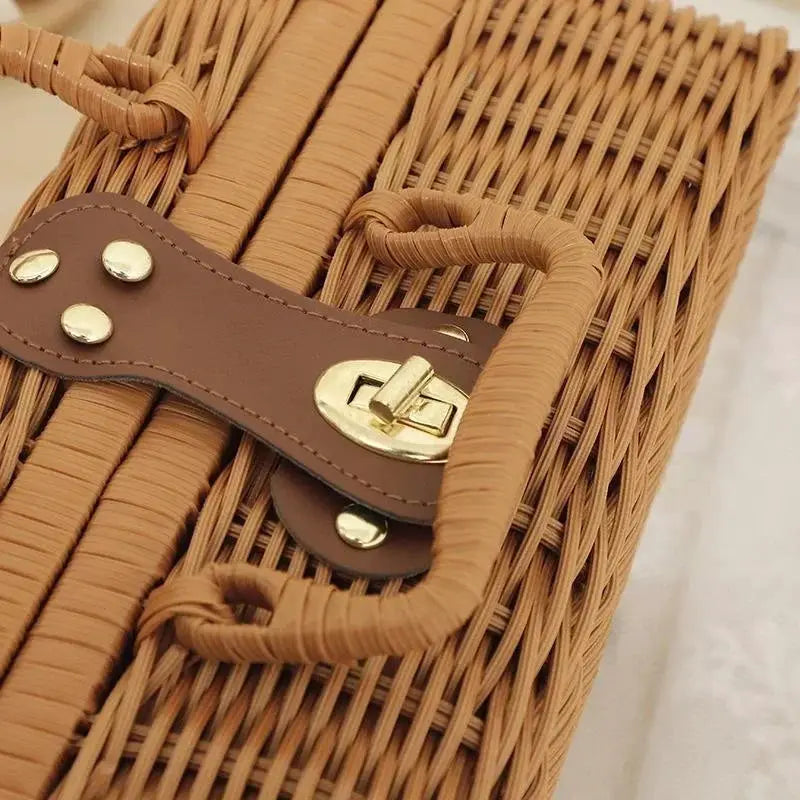 Rattan storage basket with brown leather strap and brass latch, close-up