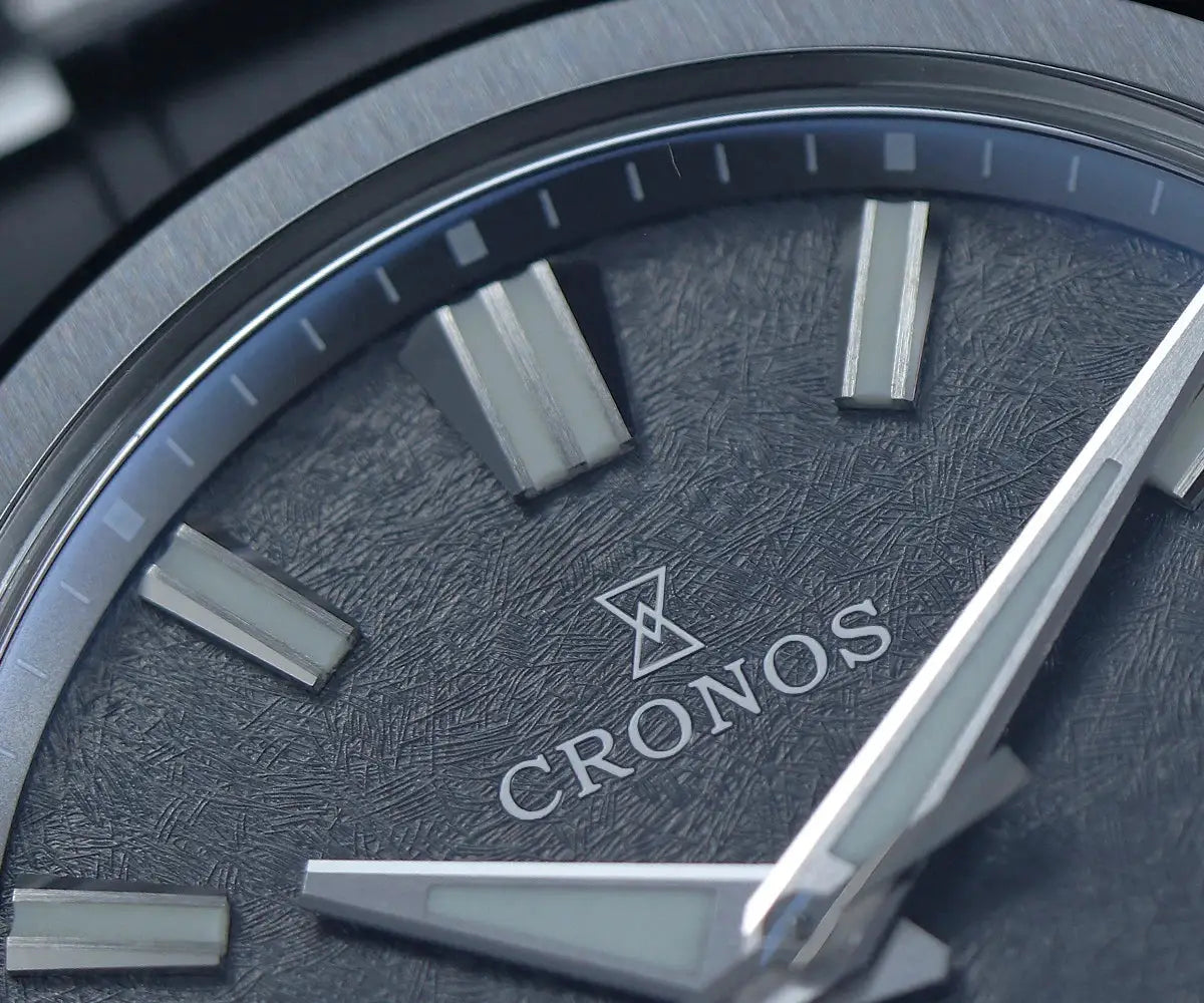 Cronos wristwatch with textured dark dial, silver indices and hands