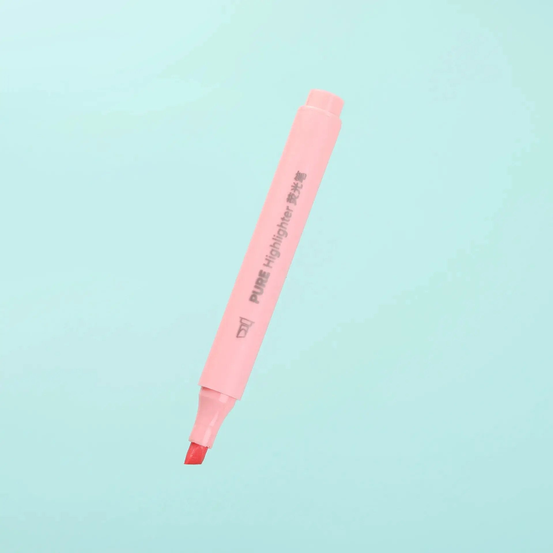 Pastel pink highlighter pen with cap on turquoise background