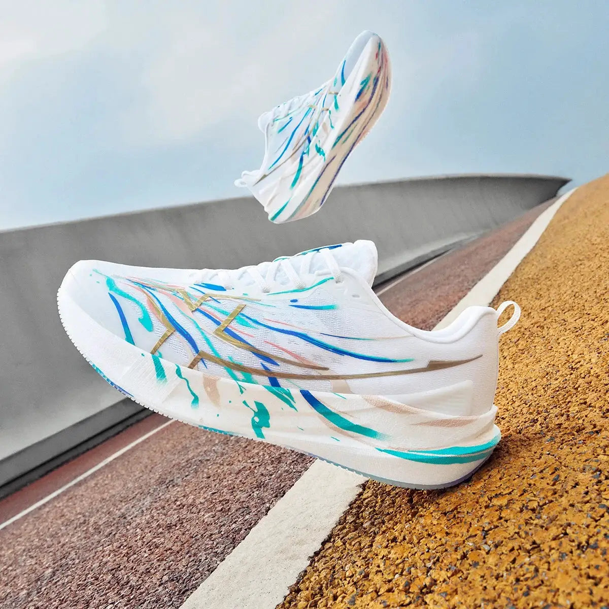 Pair of white Xtep 2000km 5.0 men's running shoes with colorful paint-splatter design