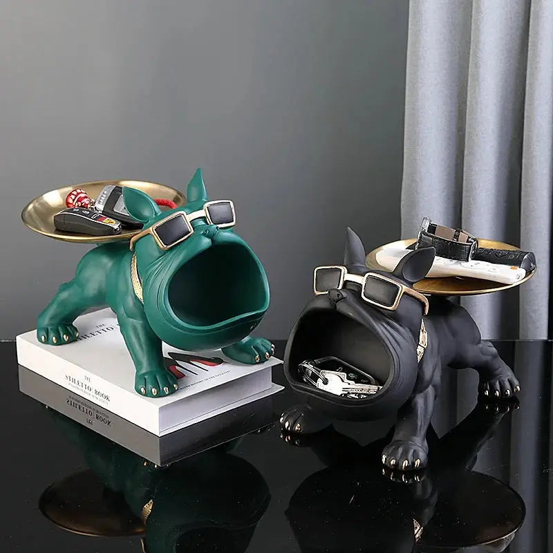 Two resin bulldog statues serving as storage trays; green and black with gold rims and sunglasses.