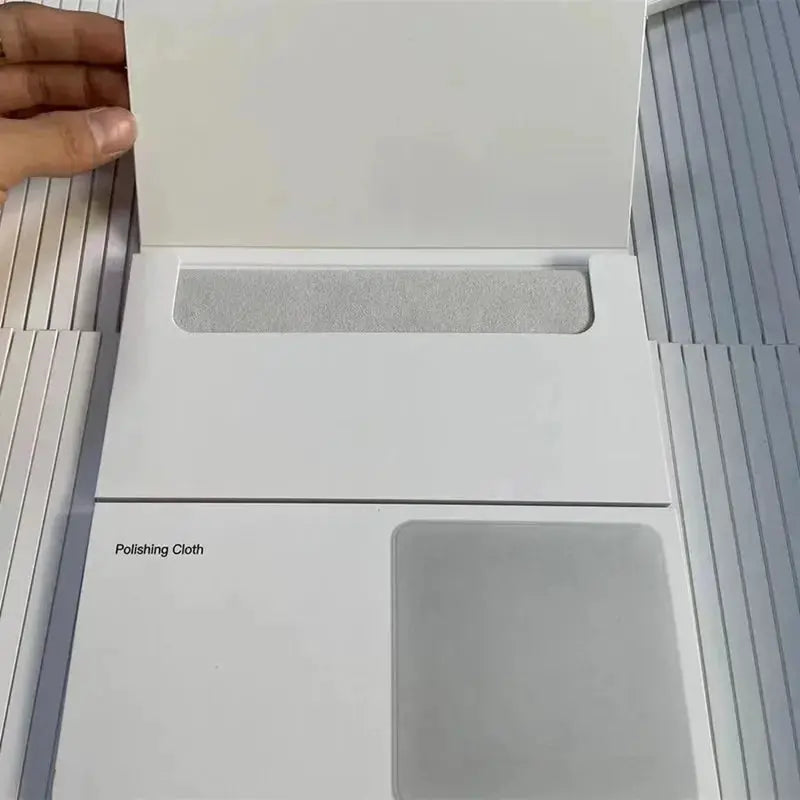 Polishing cloth for Apple devices by Simples Market; white packaging with a gray cleaning pad