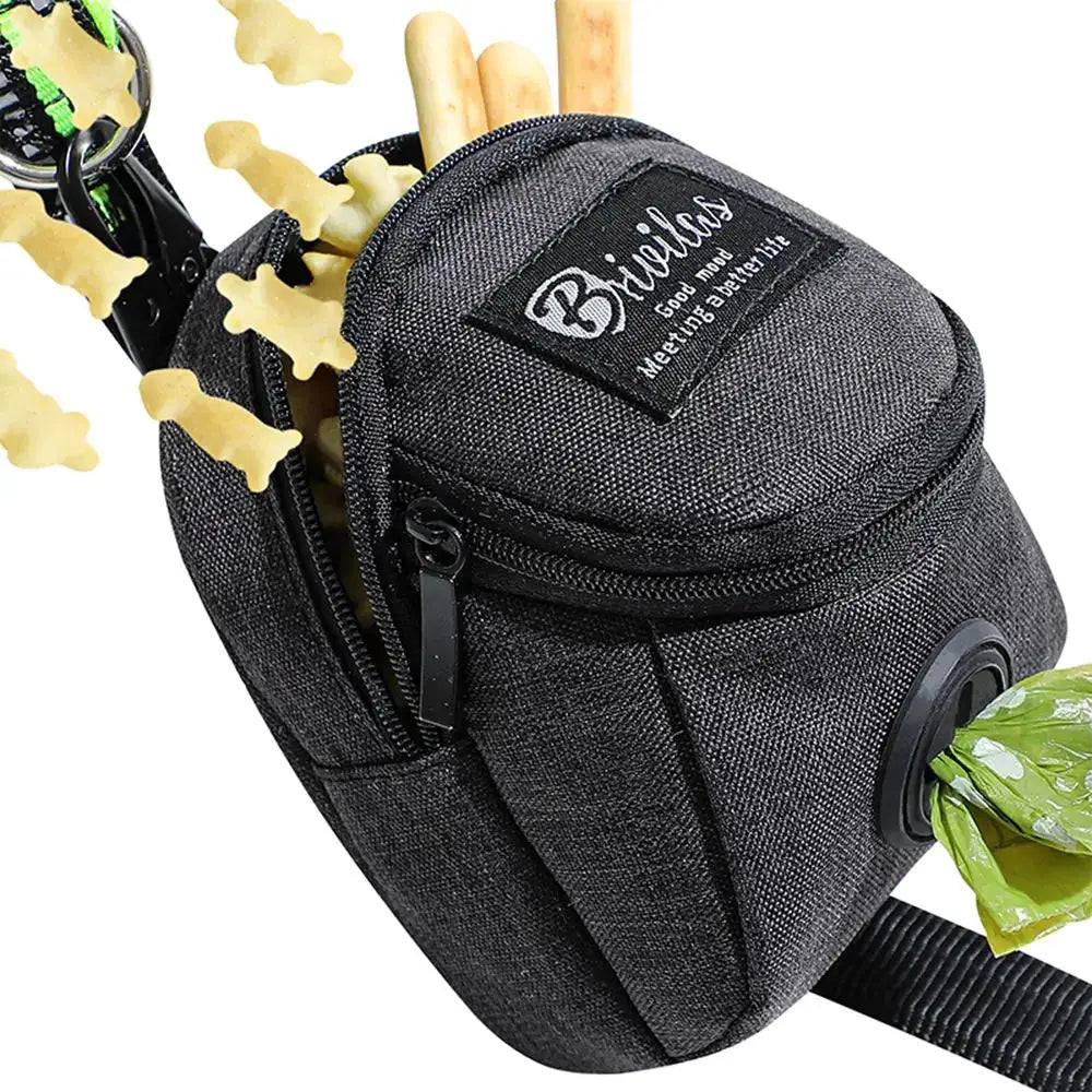 Dog treat pouch by Simples Market in black fabric with built-in poop bag dispenser and zip pocket, treats visible.
