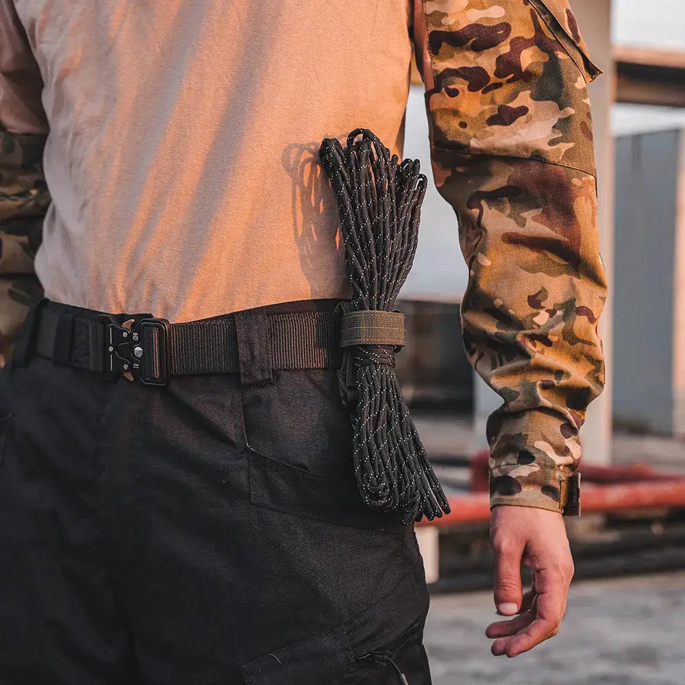 Nylon rope coiled and strapped to a tactical belt on a camo-clad worker