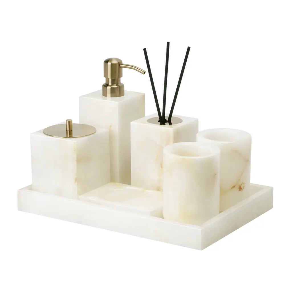 White onyx marble bathroom accessories set with gold soap dispenser, tissue box, diffuser, and cups on a tray