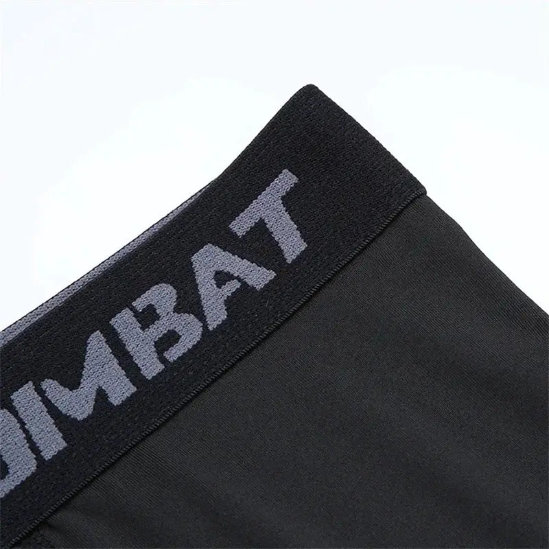 Simples Market men's black 2-in-1 compression sport pants with branded elastic waistband.