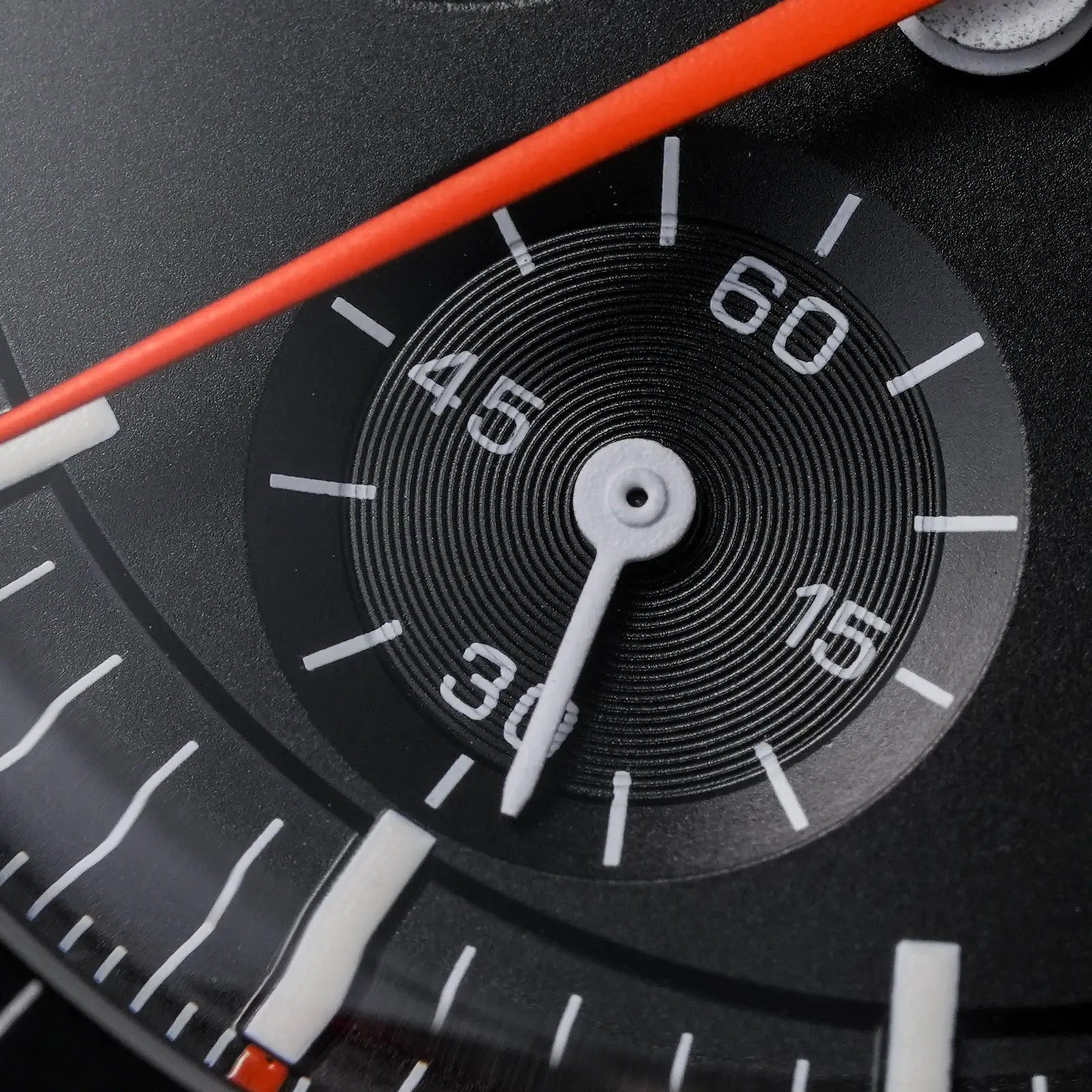 Watch dial close-up: black vintage watch with white markers and orange seconds hand