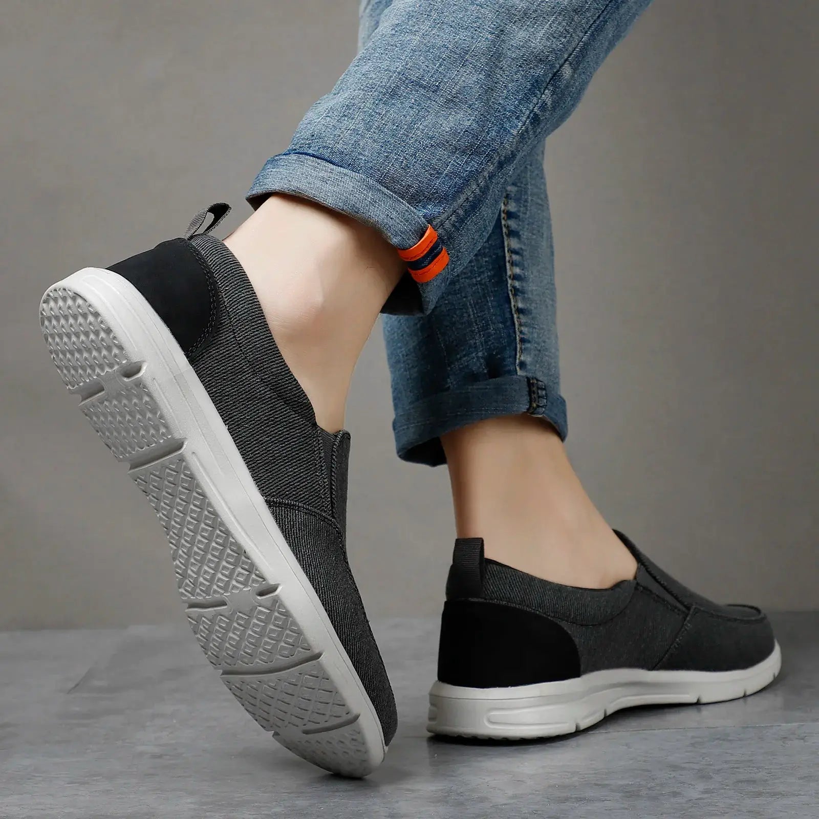 Pair of men's black canvas slip-on sneakers with breathable upper and white soles