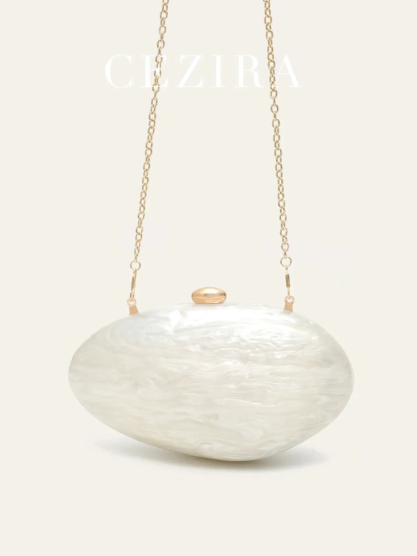Shell-shaped white acrylic clutch with long gold-tone chain and subtle clasp