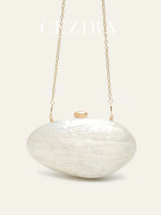 Shell-shaped white acrylic clutch with long gold-tone chain and subtle clasp