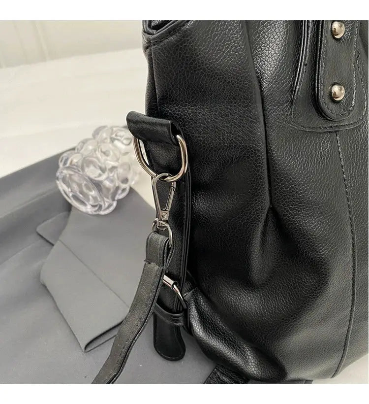 Black pebbled PU leather shoulder bag with detachable strap and metal hardware.
