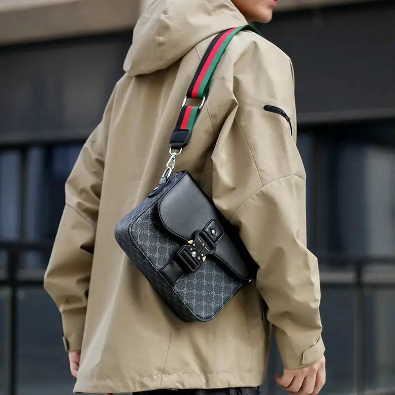 Men's jacquard crossbody bag in gray with a black buckle flap and a green-red-green striped shoulder strap