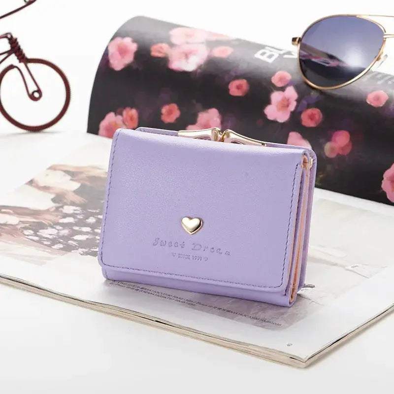Purple mini folding wallet with gold heart emblem, a cute female purse.