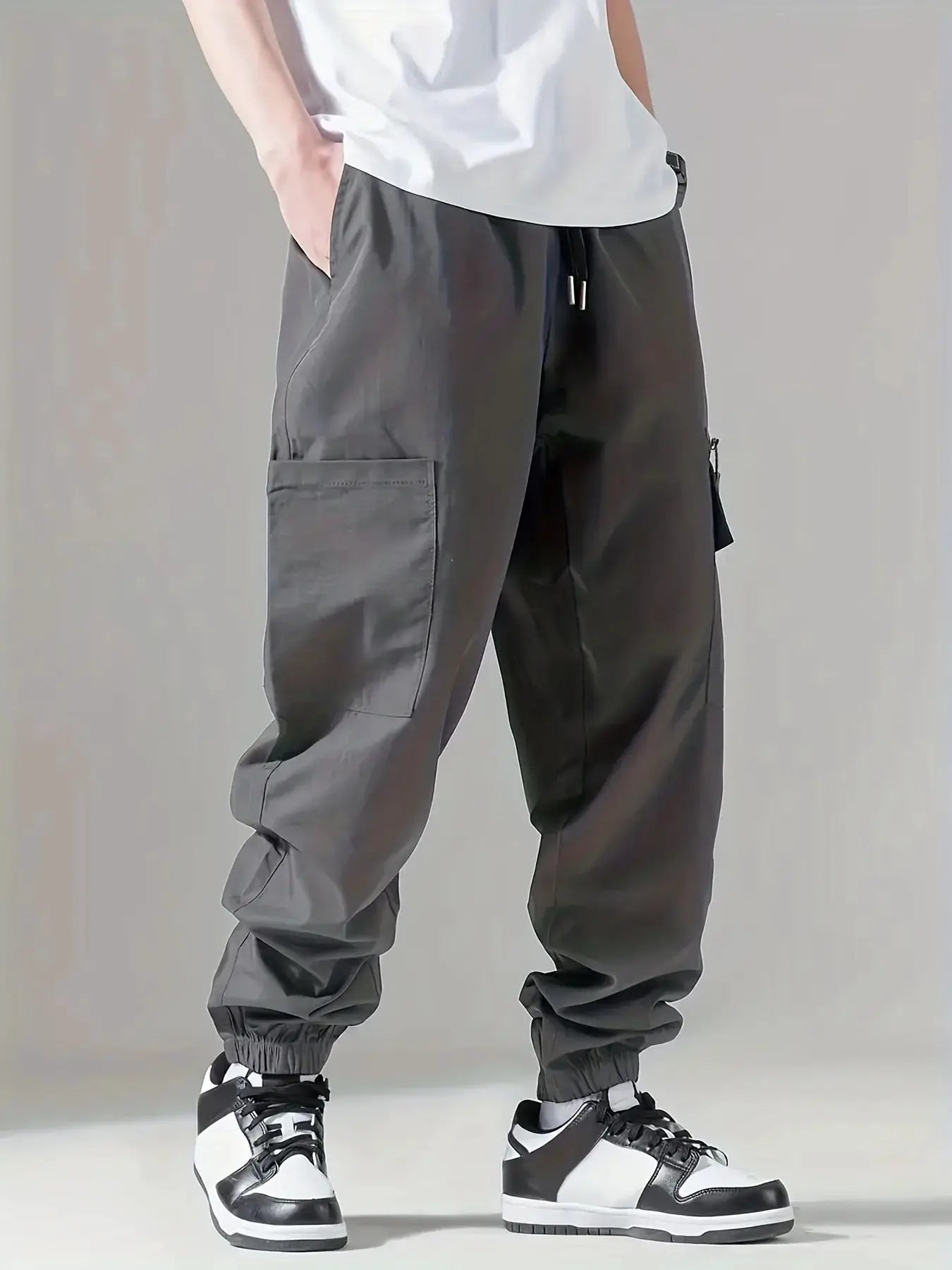 Men's cargo pants in dark gray with multiple pockets, drawstring waist and elastic cuffs