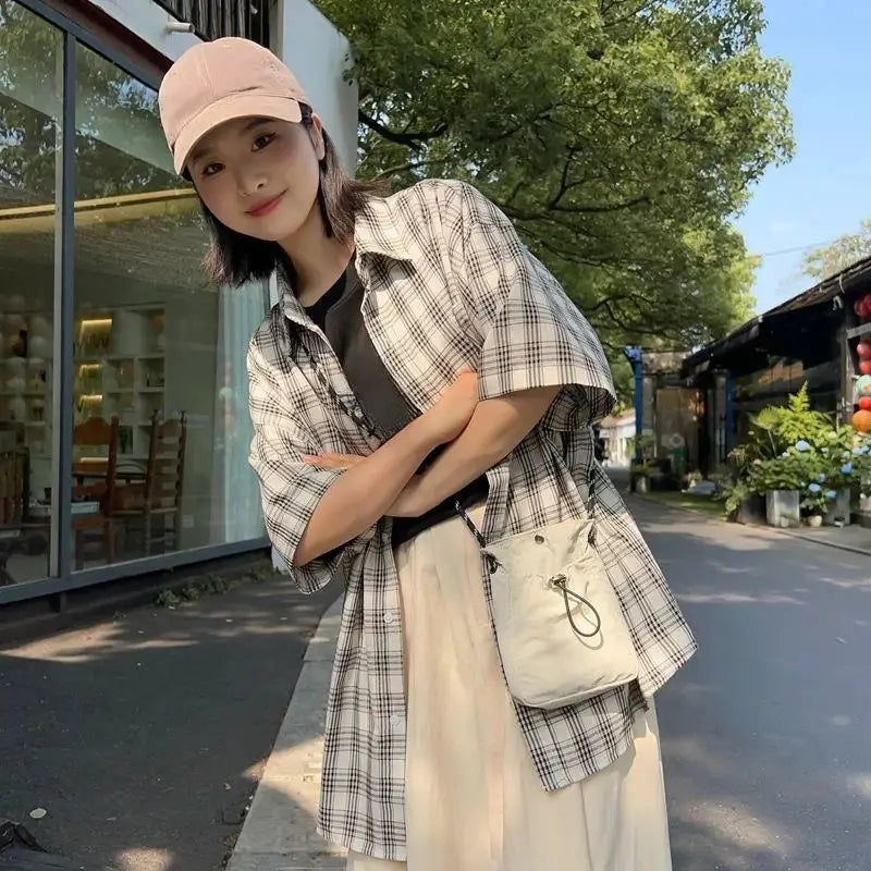 Nylon crossbody bag in cream worn by woman in plaid shirt; Simples Market.