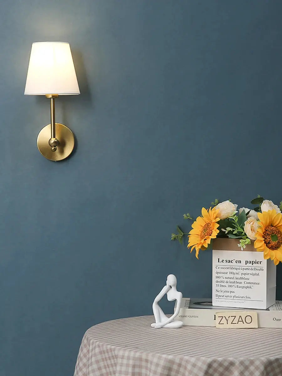 American retro brass wall lamp with white fabric shade on blue wall