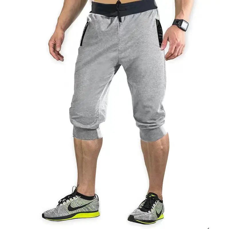 Men's grey 7/8 athletic jogger pants with elastic waistband and zip pockets, Simples Market, paired with Nike sneakers
