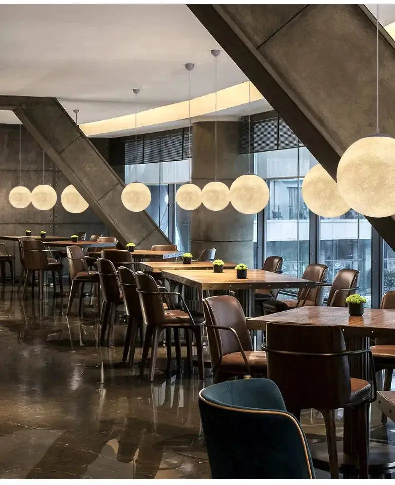 Nordic Moon Led Pendant Lights by Simples Market; group of frosted white spherical pendants over wooden dining tables.