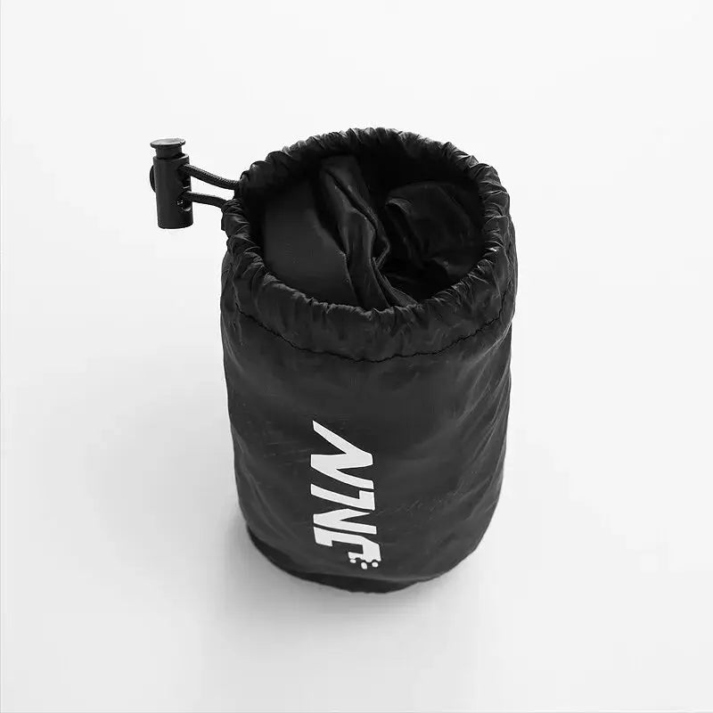 LNGXO hiking pants in black compact stuff sack with drawstring; waterproof, quick-dry, unisex outdoor trousers.