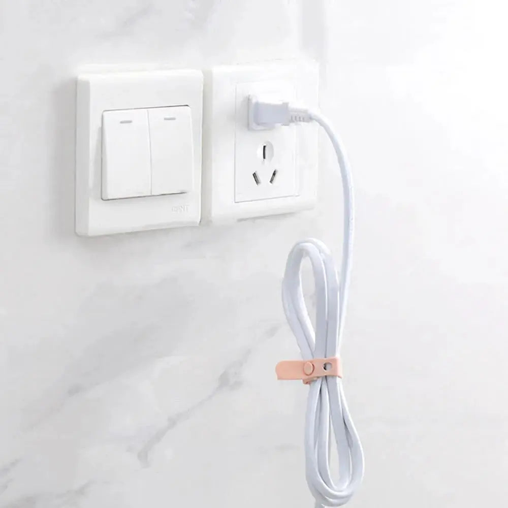 Simples Market pink silicone cable cord organizer strap securing a white power cord