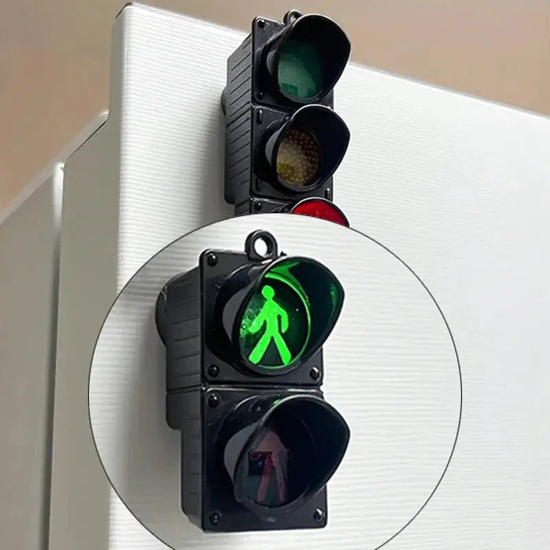 Traffic light magnetic refrigerator sticker, black plastic device with lit green pedestrian signal