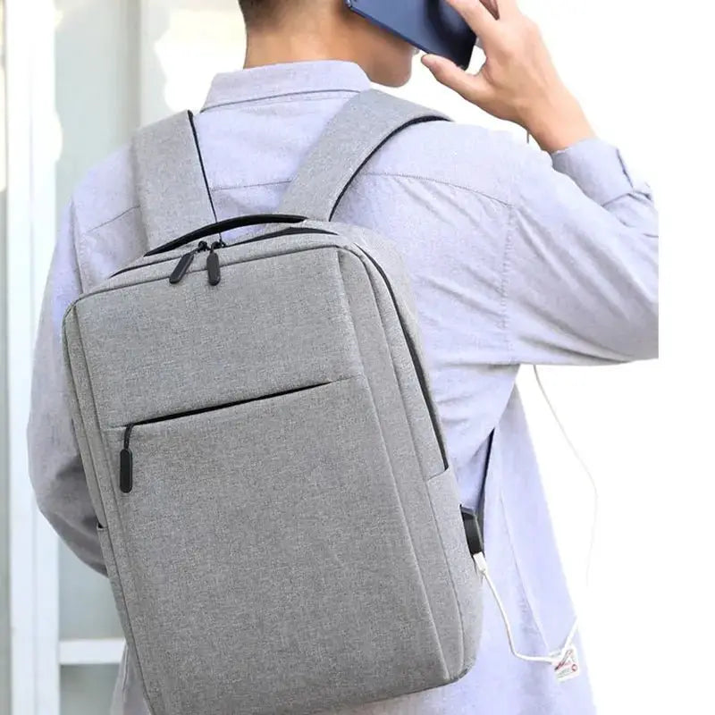 Versatile waterproof business laptop backpack worn by a person on the phone, showcasing its sleek design.