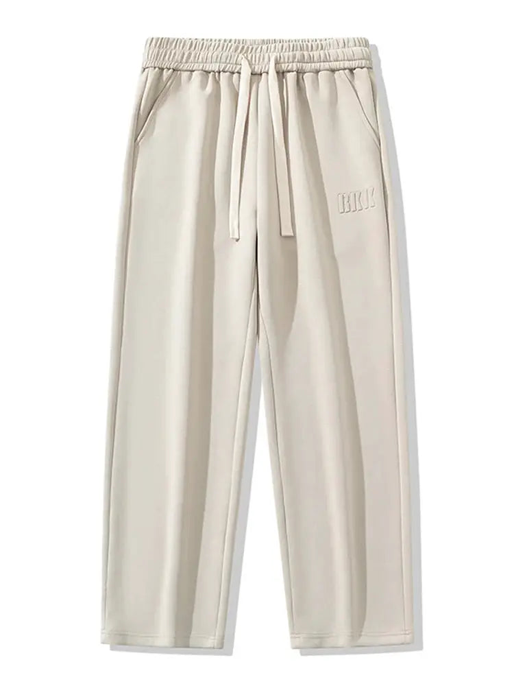 Men's beige cotton track pants with drawstring waist, straight wide-leg fit and logo embroidery on hip.