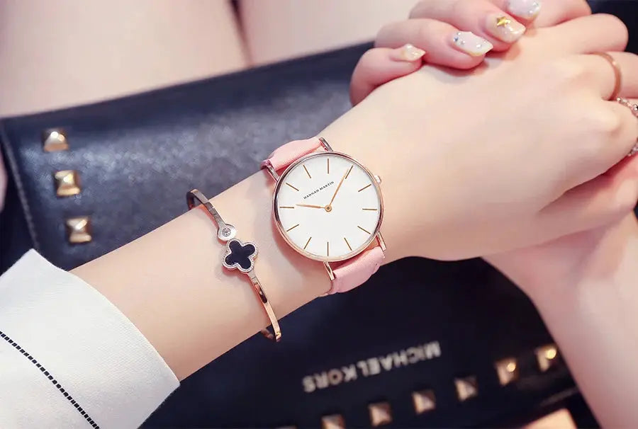 HANNAH MARTIN watch 36mm rose-gold with pink leather strap and white dial; bracelet with a black clover charm (2 items).