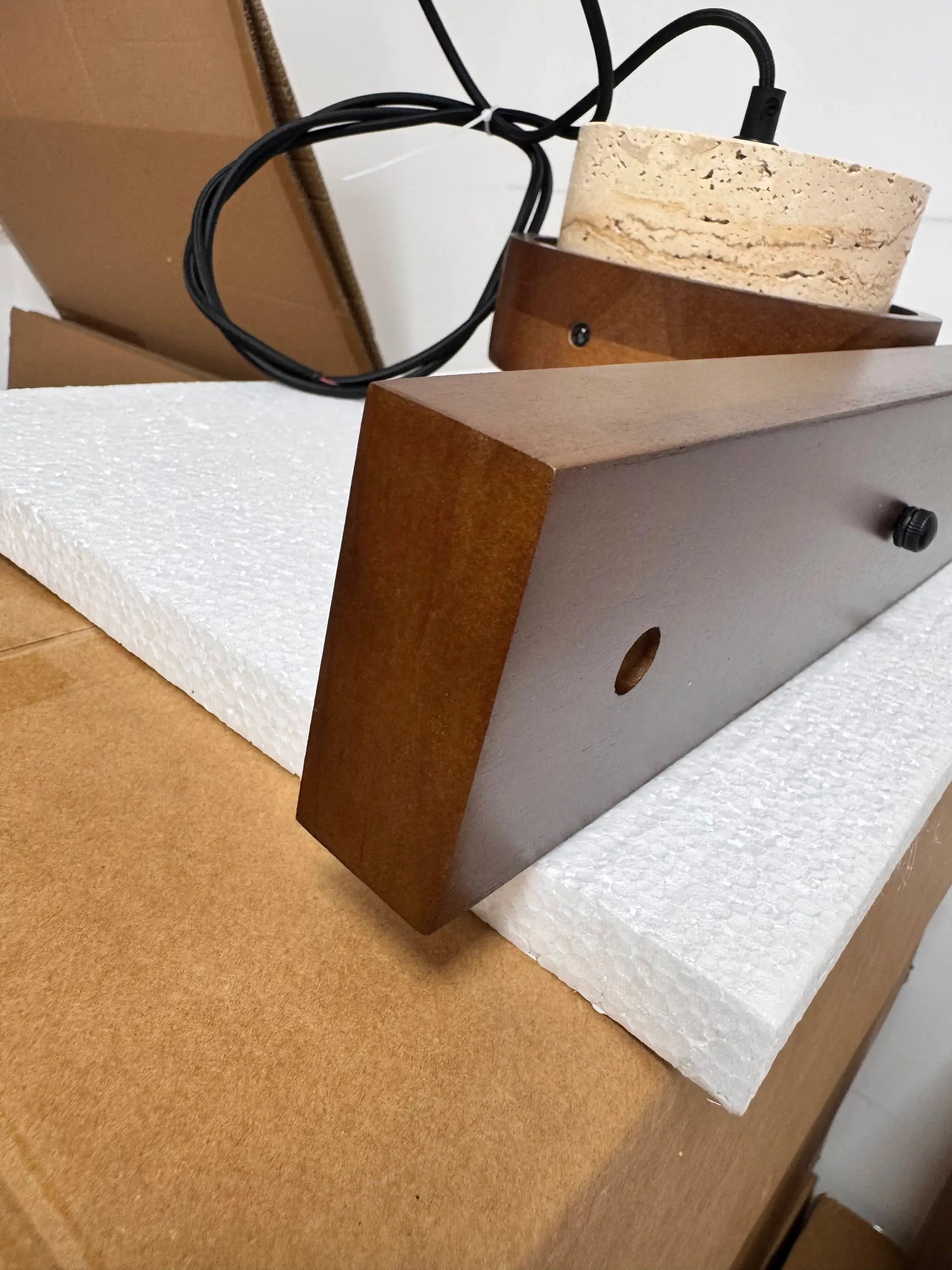 Pendant lamp components in Japanese wabi-sabi style; brown wood frame, stone block, and black cord