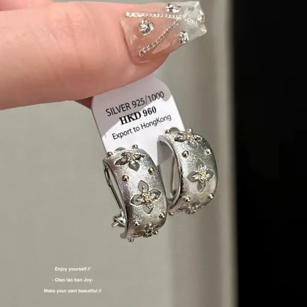 Pair of silver hollow-flower hoop earrings with zircon inlays