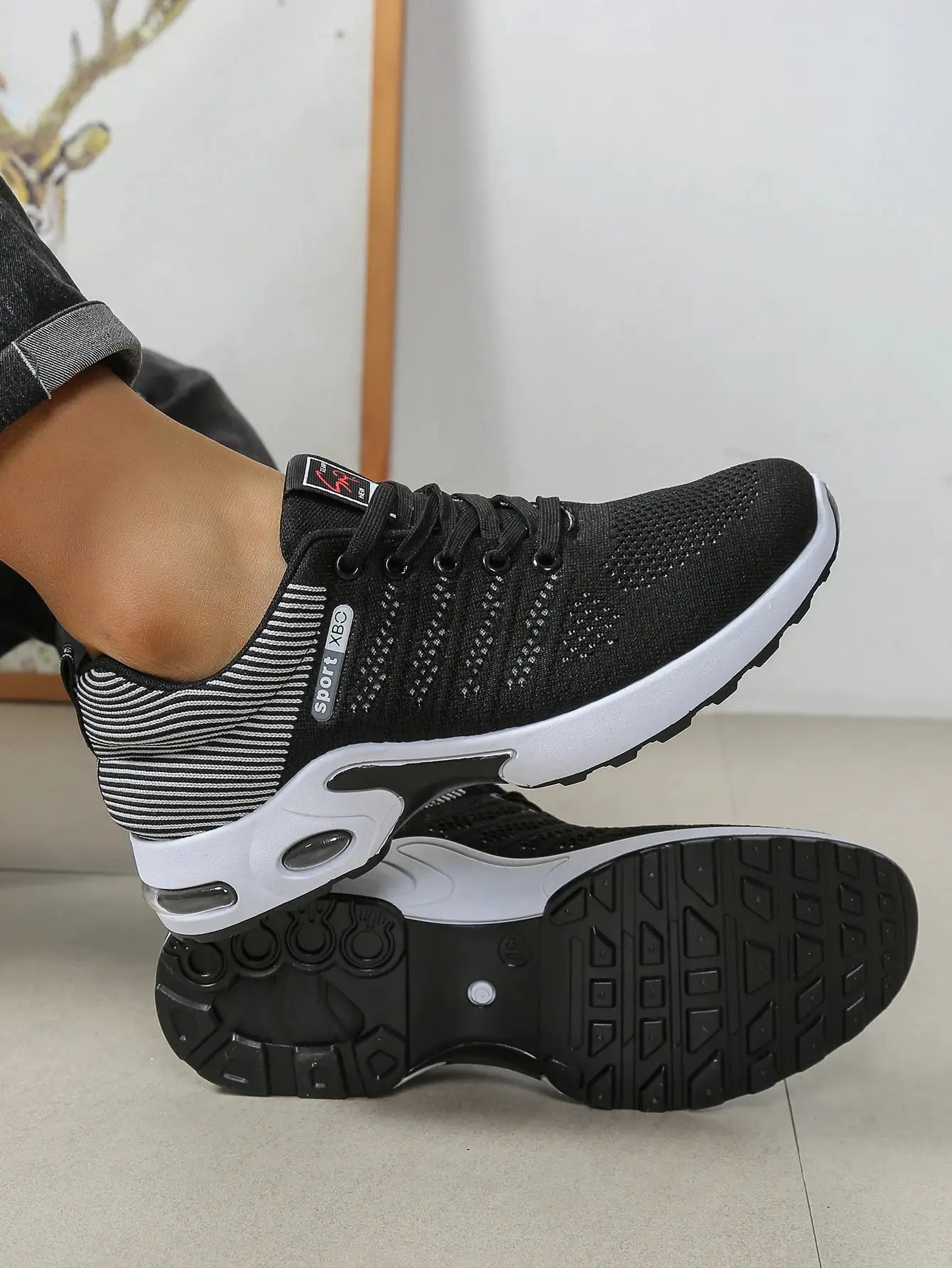 Men's black breathable lace-up running shoe with knit upper, white midsole, rugged outsole