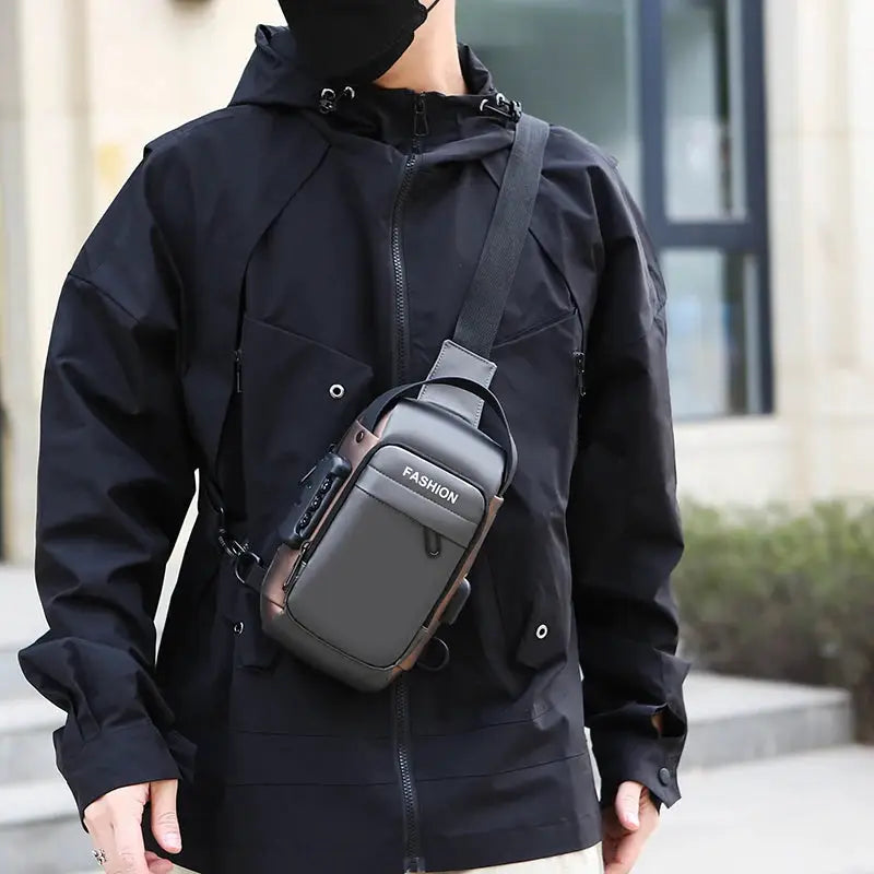 Men's anti-theft chest bag crossbody in grey with brown trim, featuring a FASHION label, worn over a black jacket.