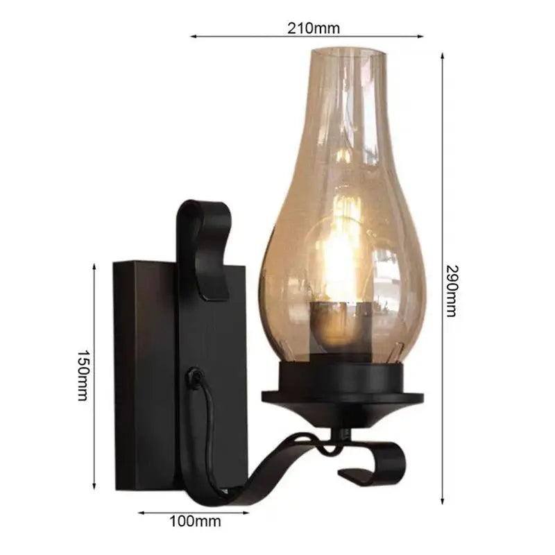 Wall lamp in black wrought iron with curved arm and amber glass teardrop shade, loft industrial style.