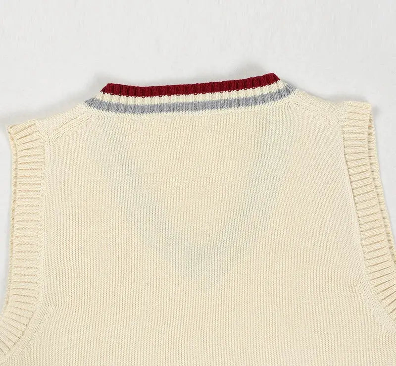 Men's cream knit sweater vest with V-neck and striped rib collar.