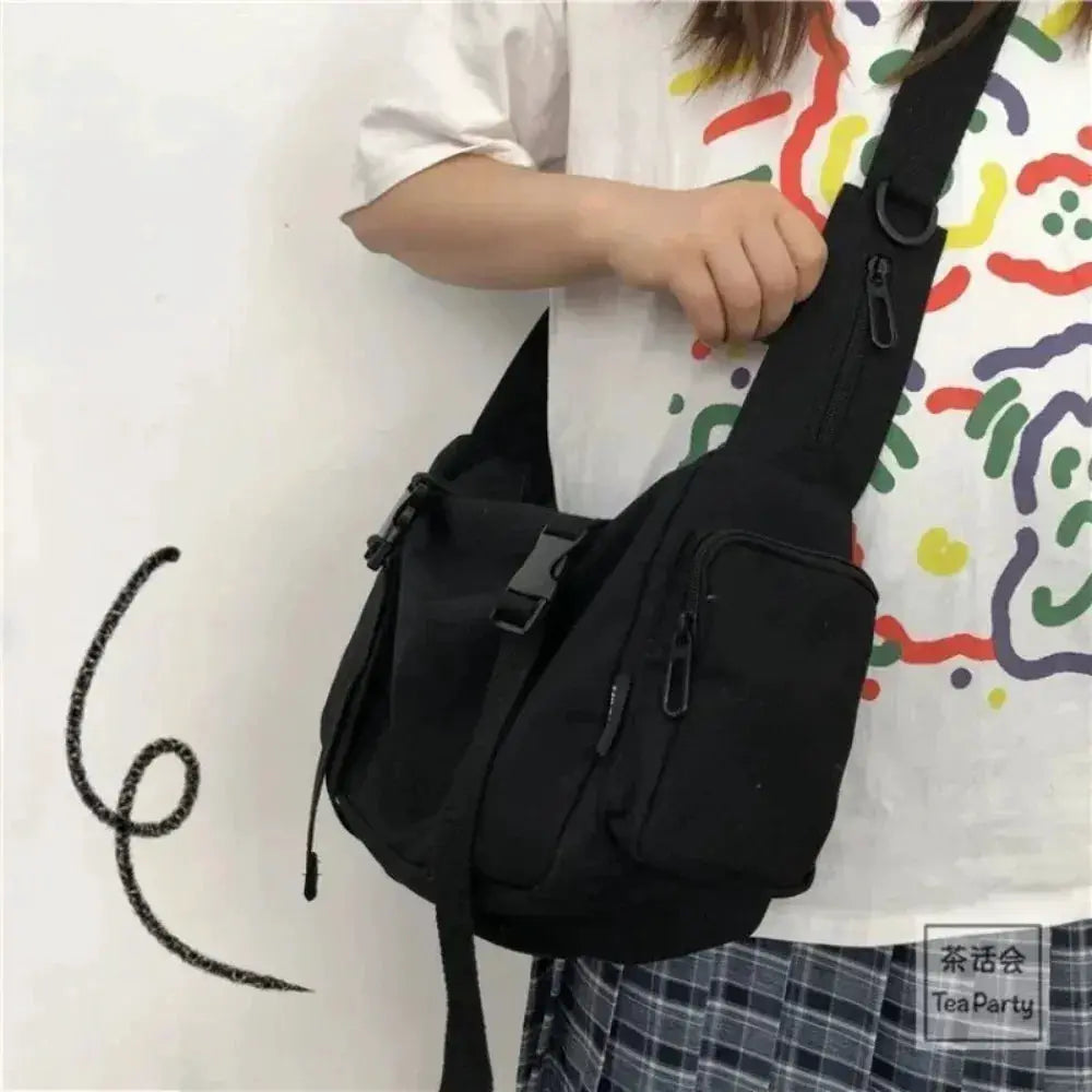 Simples Market canvas crossbody bag in black with adjustable strap and multiple zip pockets.