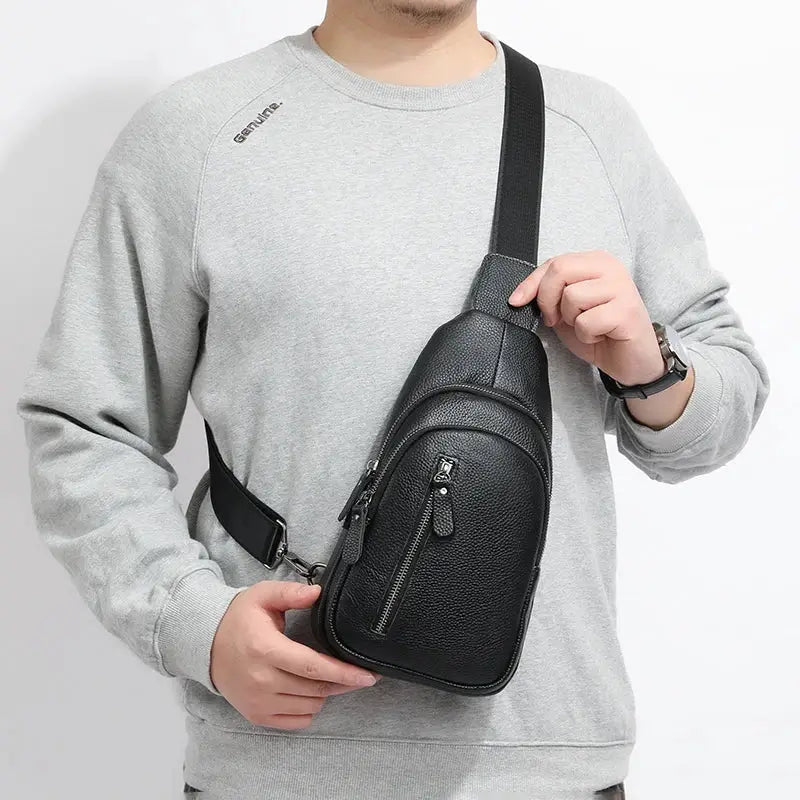 Men's black genuine leather chest bag with vertical front zipper pocket and adjustable crossbody strap.
