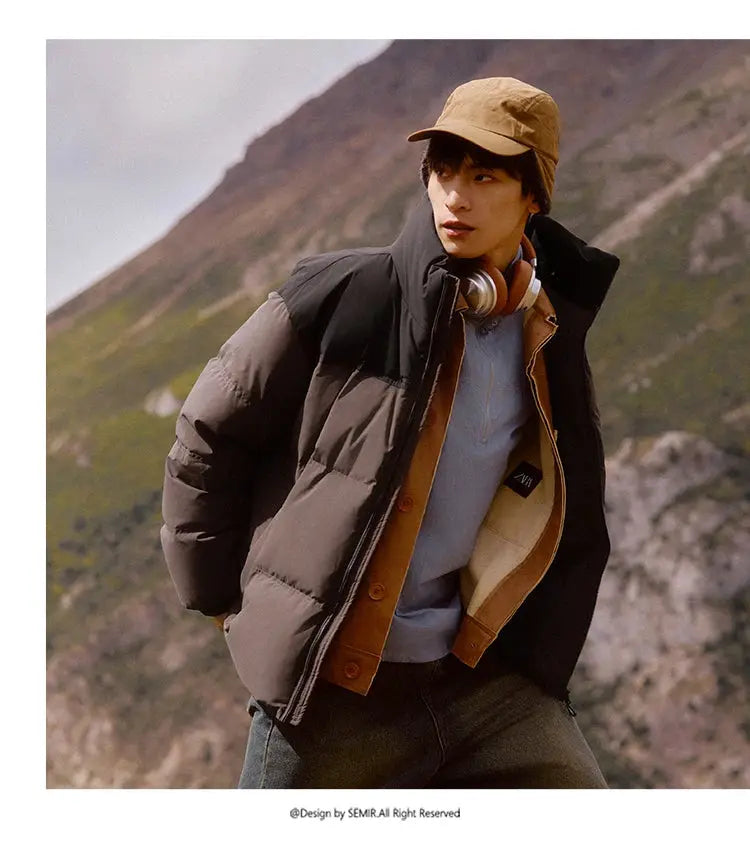 Semir down jacket in black with tan interior worn by model outdoors in mountainous scenery