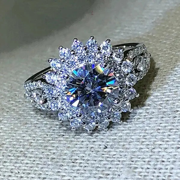 Engagement ring, silver-tone with a large central white zircon surrounded by a halo of smaller stones