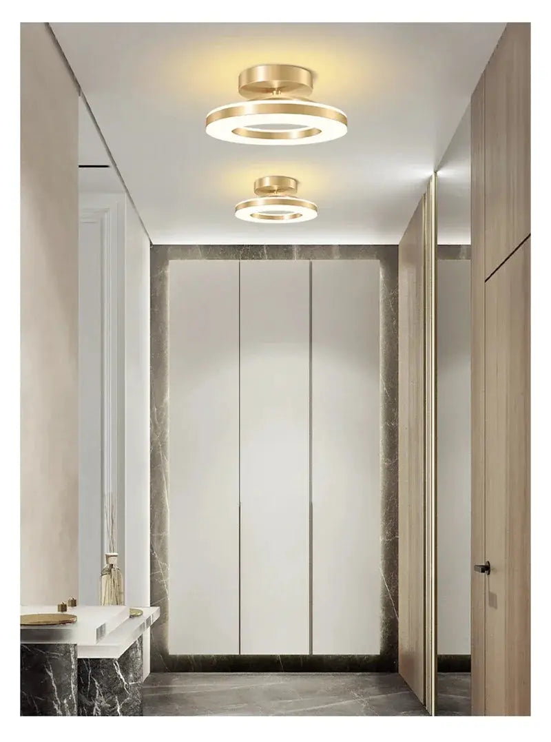 Pair of modern LED ceiling lamps with gold-brass rings and white illumination for hallway or living space