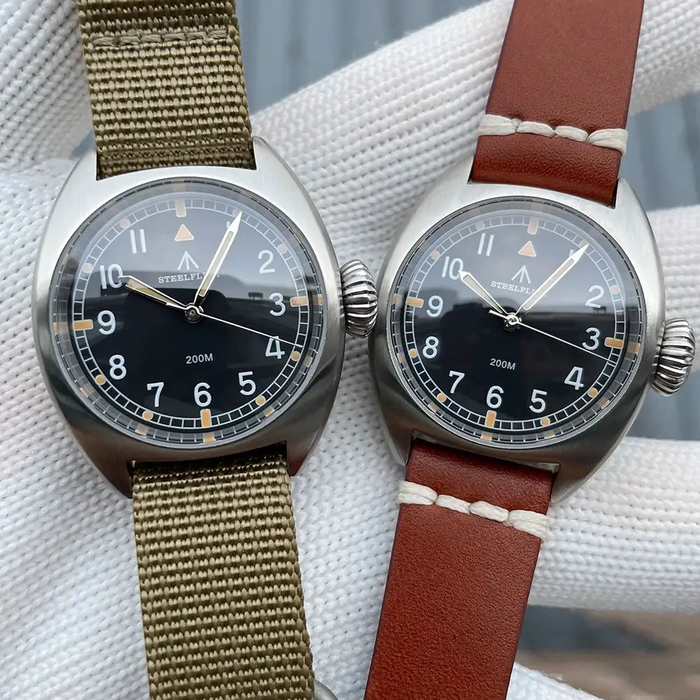 Two STEELFLIER SF745 wristwatches; black dials, stainless steel cases, olive nylon and brown leather straps.