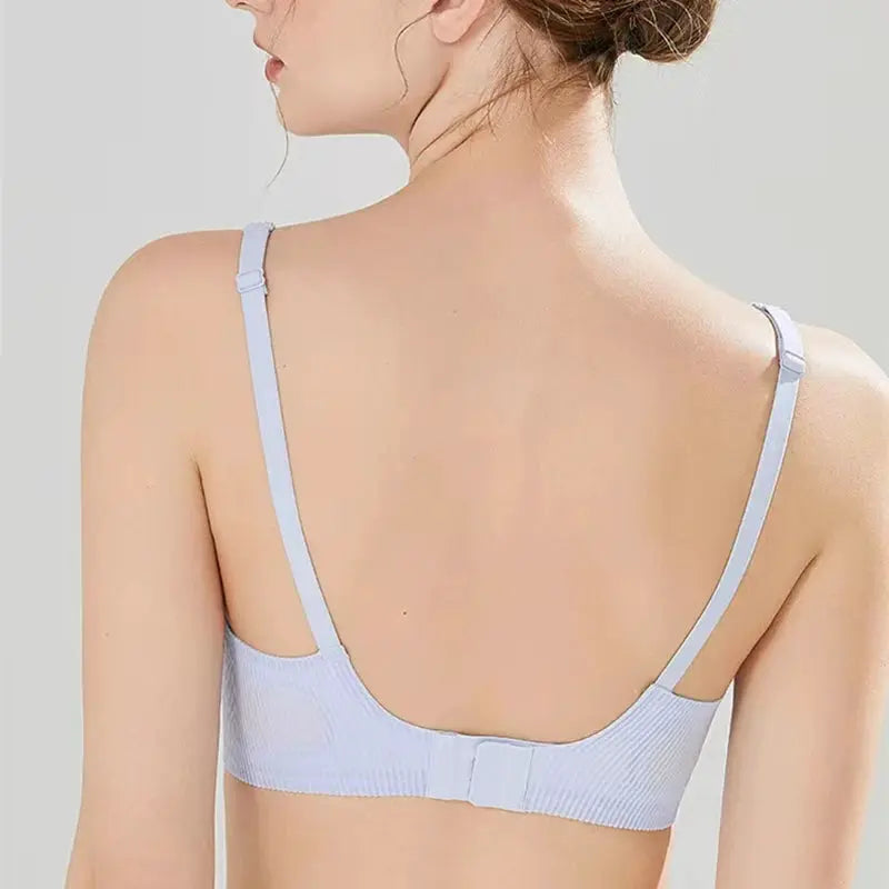 Seamless women's bra in light lavender, striped rib texture, adjustable straps, back hook closure.