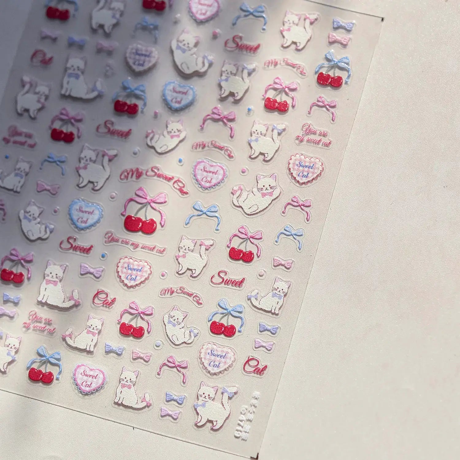 Nail art stickers sheet with pink translucent jelly texture, 5D embossed self-adhesive decals featuring cute cats, cherries.