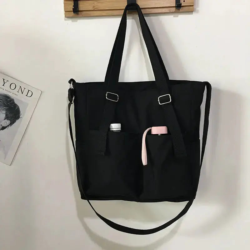 Simples Market waterproof Oxford large-capacity women handbag, black tote with dual handles and shoulder strap.