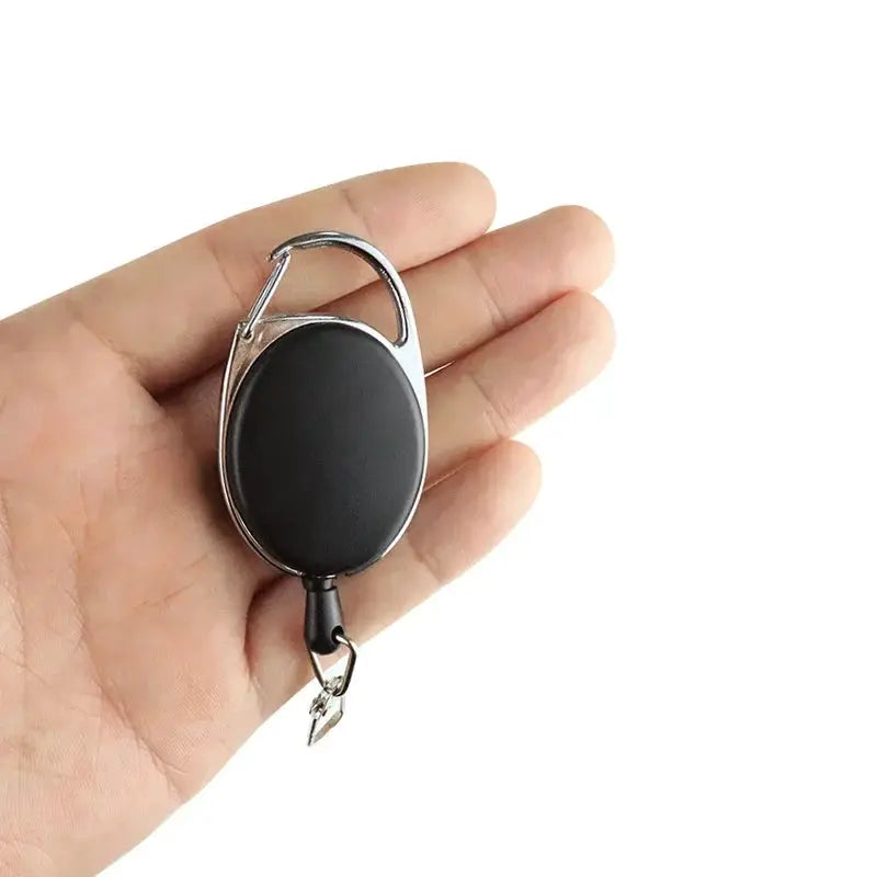 Simples Market retractable key chain reel badge holder, black oval reel with silver metal clip.