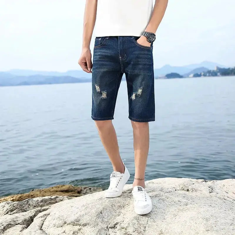 Men's dark blue denim knee-length shorts with distressed patches