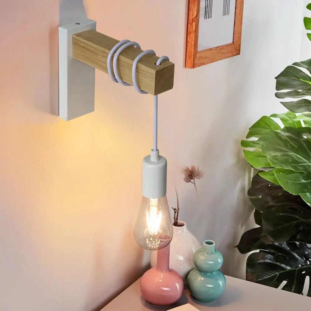 Wall lamp with wooden beam and gray socket, Edison bulb, mounted on a white wall