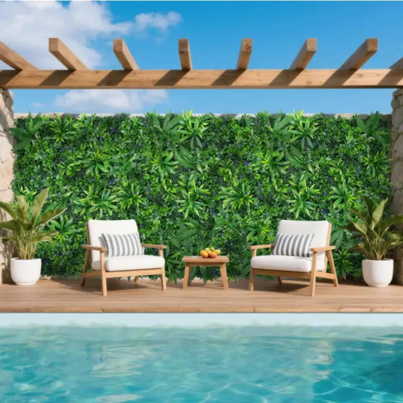 Artificial boxwood grass wall panel by Simples Market; two white-cushioned wooden chairs on a wooden deck.