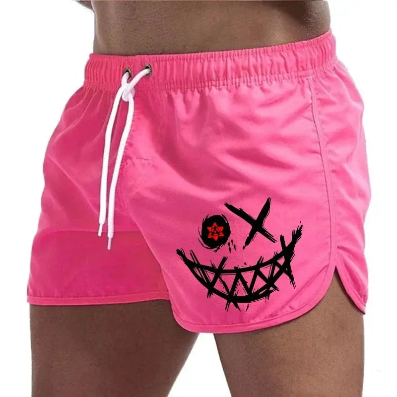 Pink men's board shorts with white drawstring and a black grunge smiley graphic on the left leg.