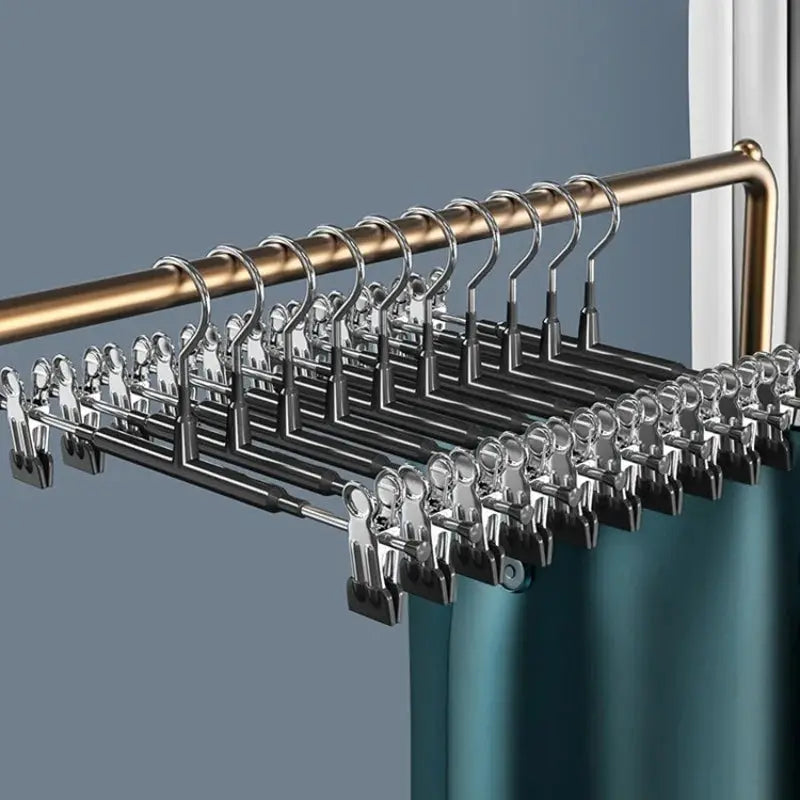 Stainless steel clothes drying rack with chrome clip hangers on a rod